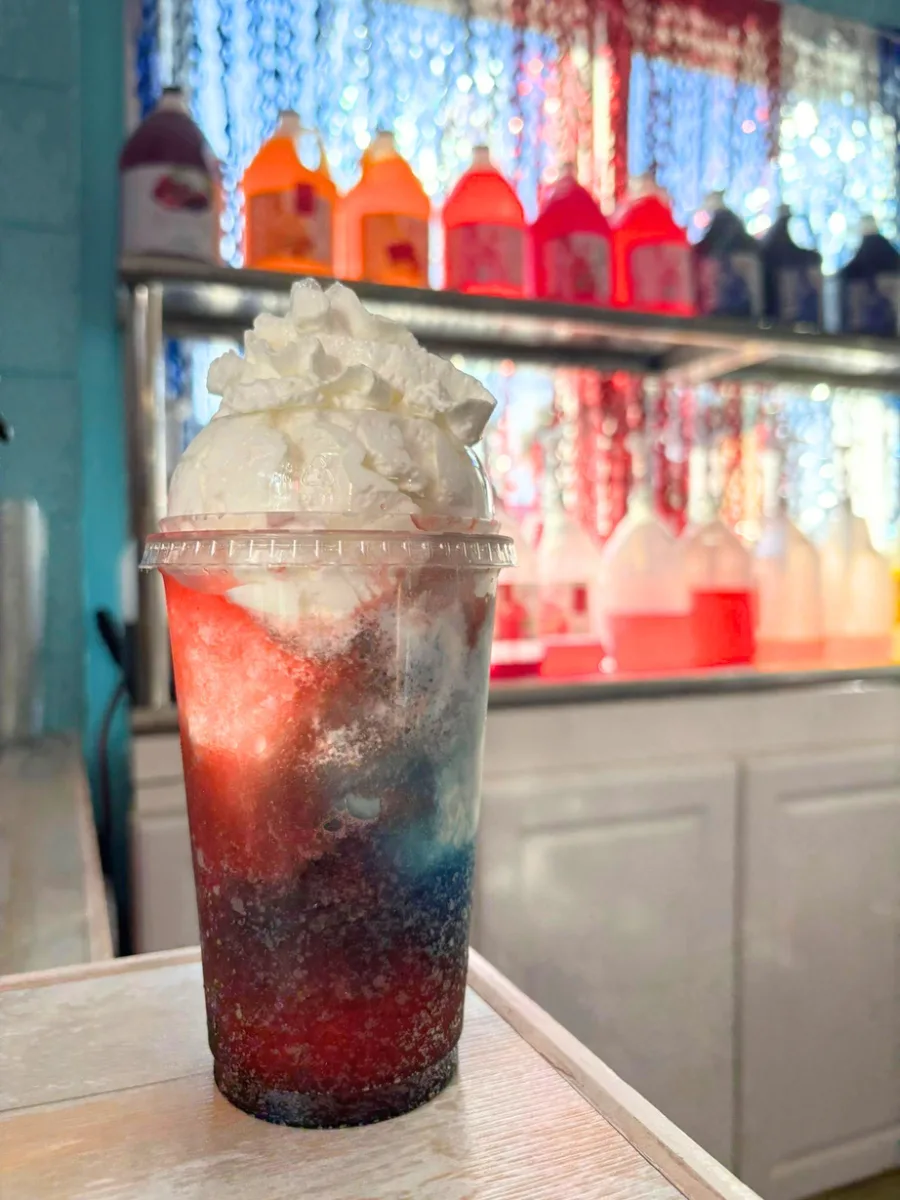 A layered red, white, and blue slushie in a cup
